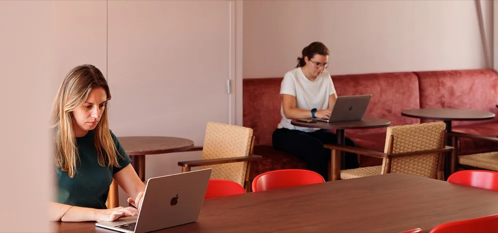 Two people working on laptops in a Morning coworking space