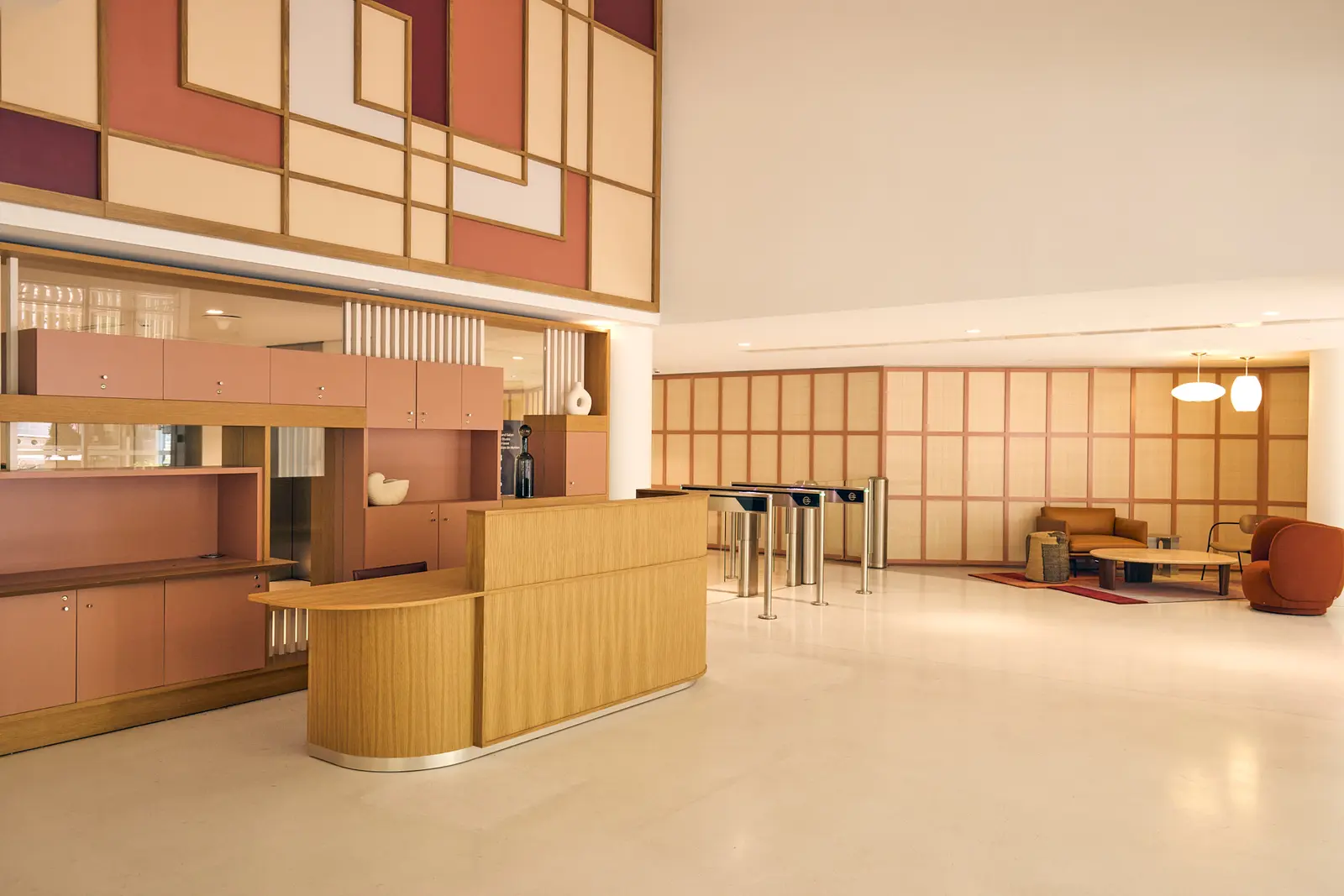 Hall d'accueil d'un immeuble de bureaux avec banque d'accueil en bois et portiques de sécurité