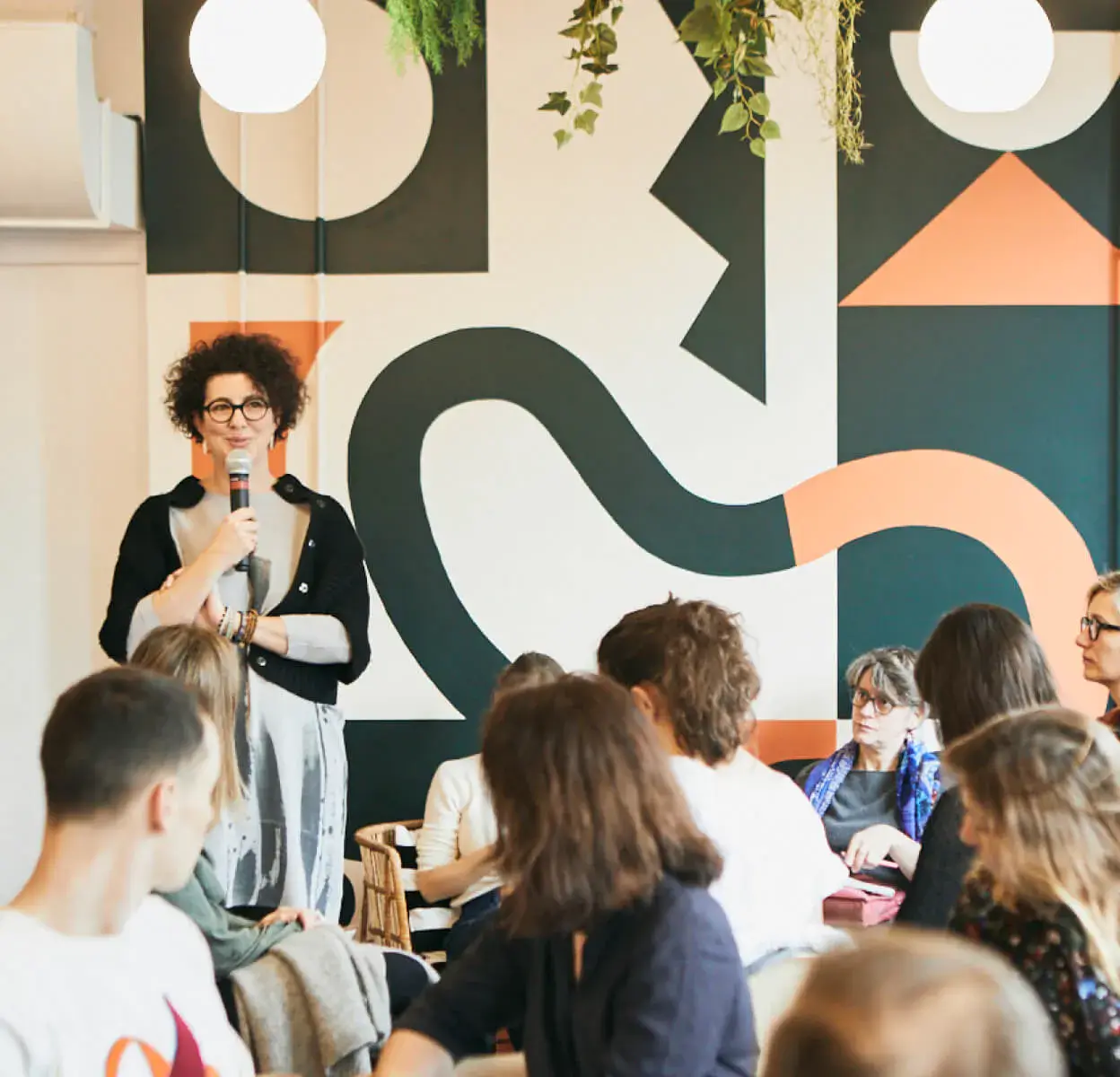Speaker addressing a group of colleagues in a Morning workspace in Paris